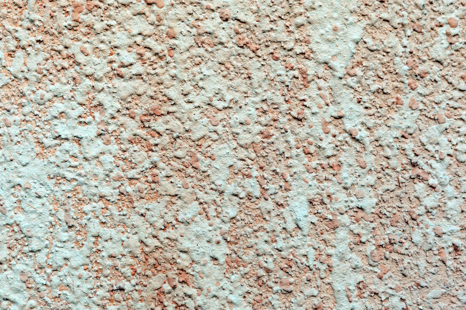 Textured background of light colored surface covered with plaster on wall of building